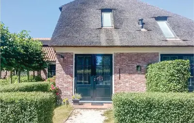 a house with a black door and a roof at De Koestal in Wijdenes