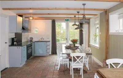 a kitchen with a table and chairs in a room at De Koestal in Wijdenes