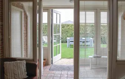an open door to a patio with a view of a yard at De Koestal in Wijdenes