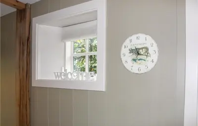 a clock on a wall next to a window at De Koestal in Wijdenes