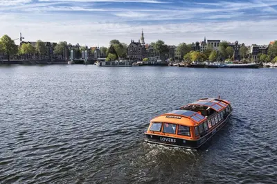 an orange and black boat traveling down a river at Felicitas in Amsterdam