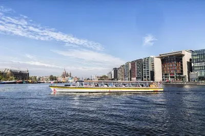 a boat filled with people on a river with buildings at Felicitas in Amsterdam