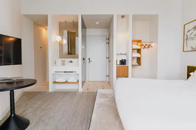 a bedroom with a white bed and a table at Hotel Pontsteiger in Amsterdam