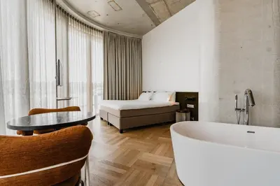 a bathroom with a tub and a bed in a room at Hotel Pontsteiger in Amsterdam