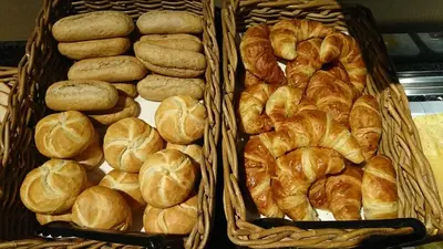 two baskets filled with buns and croissants at Fletcher Hotel-Restaurant Het Witte Huis in Amersfoort