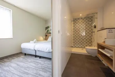 a bathroom with a bed and a shower and a toilet at Fletcher Hotel-Restaurant Het Witte Huis in Amersfoort