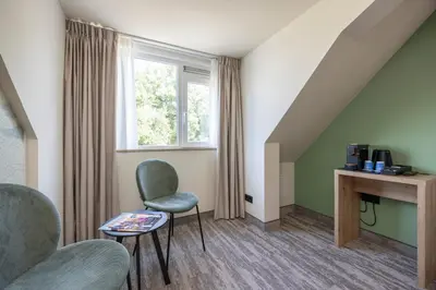 a room with two chairs and a desk and a window at Fletcher Hotel-Restaurant Het Witte Huis in Amersfoort