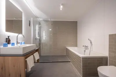 a bathroom with a sink and a tub and a toilet at Fletcher Hotel-Restaurant Het Witte Huis in Amersfoort