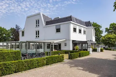 a white house with bikes parked in front of it at Fletcher Hotel-Restaurant Het Witte Huis in Amersfoort