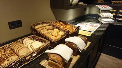 a buffet with several baskets of bread and pastries at Fletcher Hotel-Restaurant Het Witte Huis in Amersfoort