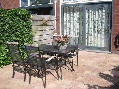 a black table and chairs with flowers on a patio at Quarenta Studio in Amsterdam