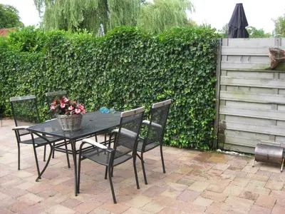 a black table and chairs with flowers on a patio at Quarenta Studio in Amsterdam