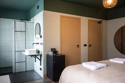 a bathroom with a bed and a sink and a mirror at Seabreeze Suites - near Zandvoort aan Zee in Overveen