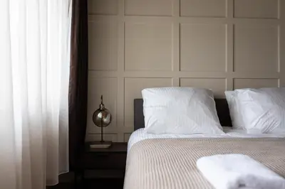 a bedroom with a bed with white sheets and pillows at Seabreeze Suites - near Zandvoort aan Zee in Overveen