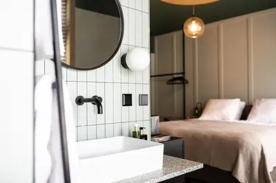 a bathroom with a sink and a bed at Seabreeze Suites - near Zandvoort aan Zee in Overveen