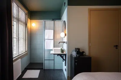 a room with a bathroom with a sink and a mirror at Seabreeze Suites - near Zandvoort aan Zee in Overveen