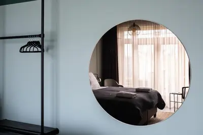 a bedroom with a bed and a mirror at Seabreeze Suites - near Zandvoort aan Zee in Overveen