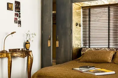 a bedroom with a bed with a table and a window at B&B Habitat in Beverwijk