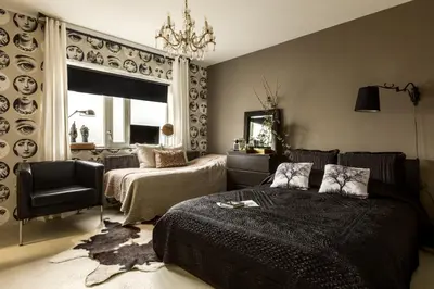 a bedroom with two beds and a chair and a chandelier at B&B Habitat in Beverwijk