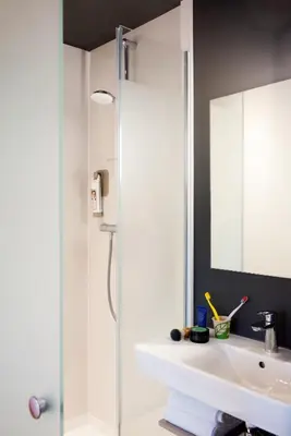 a bathroom with a shower and a sink and a mirror at ibis budget Amsterdam Airport in Badhoevedorp