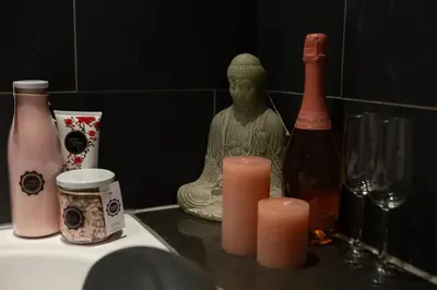 a statue of a buddha next to some bottles and candles at Jacuzzi Amsterdam Center Apartment Sunny Top Floor in Amsterdam