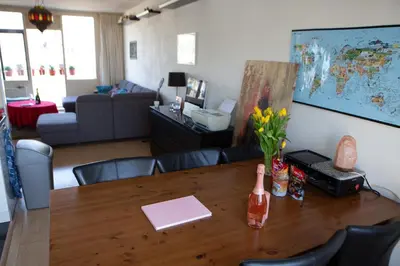 a living room with a wooden table with flowers on it at Jacuzzi Amsterdam Center Apartment Sunny Top Floor in Amsterdam