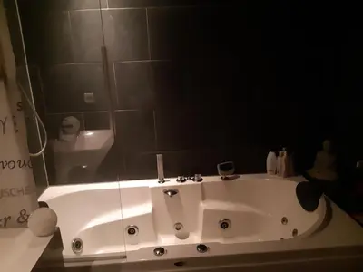 a bathroom with a white bath tub with a mirror at Jacuzzi Amsterdam Center Apartment Sunny Top Floor in Amsterdam