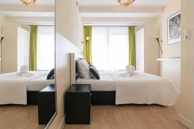 two beds in a room with a mirror at B&B Canaliscious in Amsterdam