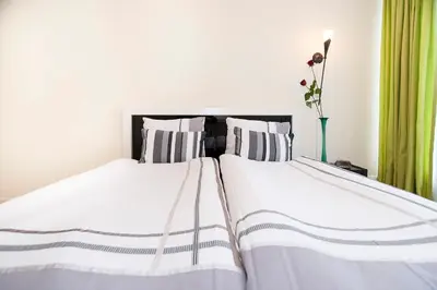 two beds in a bedroom with green curtains at B&B Canaliscious in Amsterdam