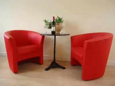 two red chairs and a table with a bottle of wine at B&B Canaliscious in Amsterdam