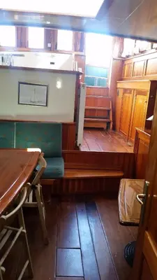 a room with a table and a bench in a boat at Tjalkjacht Pelikaan Volendam in Volendam