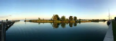 a large body of water with trees and a dock at Tjalkjacht Pelikaan Volendam in Volendam