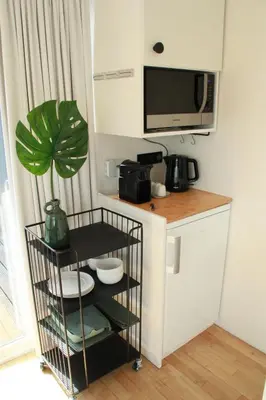 a small kitchen with a shelf and a microwave at Houseboat Studio Sooki in Amsterdam