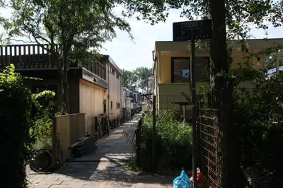 a street sign on a sidewalk next to a building at Houseboat Studio Sooki in Amsterdam