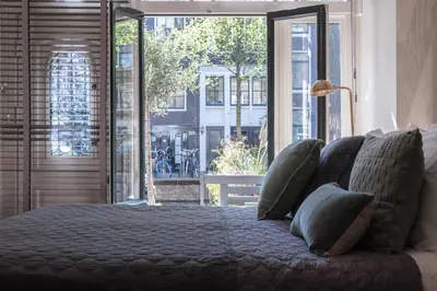 a bedroom with a bed and a large window at Villa360 in Amsterdam