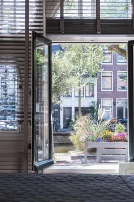 an open sliding glass door with a bench outside at Villa360 in Amsterdam