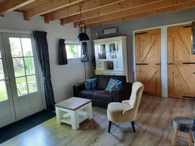 a living room with a couch and a table at Chalet in Castricum