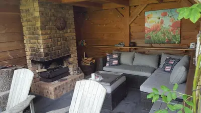 a porch of a cabin with a brick fireplace at Chalet in Castricum