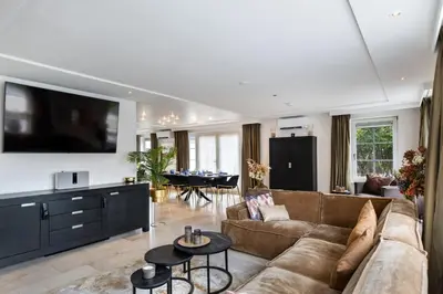 a living room with a couch and a dining room at Casa Grande - cityview Amsterdam in Landsmeer