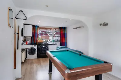 a pool table in a living room with a washer and dryer at Casa Grande - cityview Amsterdam in Landsmeer