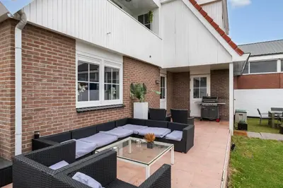 a patio with a black couch and a glass table at Casa Grande - cityview Amsterdam in Landsmeer