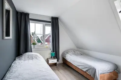 two beds in a small room with a window at Casa Grande - cityview Amsterdam in Landsmeer