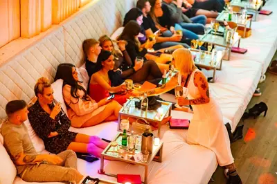 a group of people sitting on benches in a room at SUPPER Hotel in Amsterdam