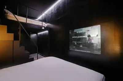 a bedroom with a bed and a tv on the wall at SUPPER Hotel in Amsterdam