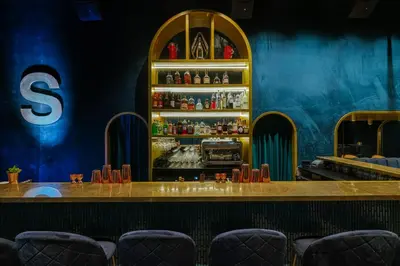 a bar at a restaurant with blue walls and chairs at SUPPER Hotel in Amsterdam