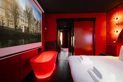 a red room with a bed and a red chair at SUPPER Hotel in Amsterdam