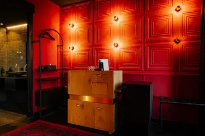 a red wall with a refrigerator in a room at SUPPER Hotel in Amsterdam
