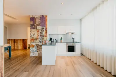 a kitchen with white appliances and a wooden floor at Amsterdam ID Aparthotel in Amsterdam