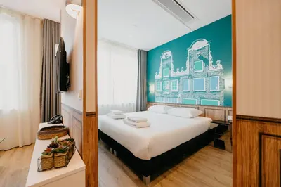 a bedroom with a large bed with a blue wall at Amsterdam ID Aparthotel in Amsterdam