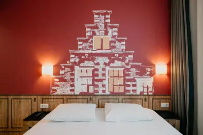 a bedroom with two beds and a red wall at Amsterdam ID Aparthotel in Amsterdam
